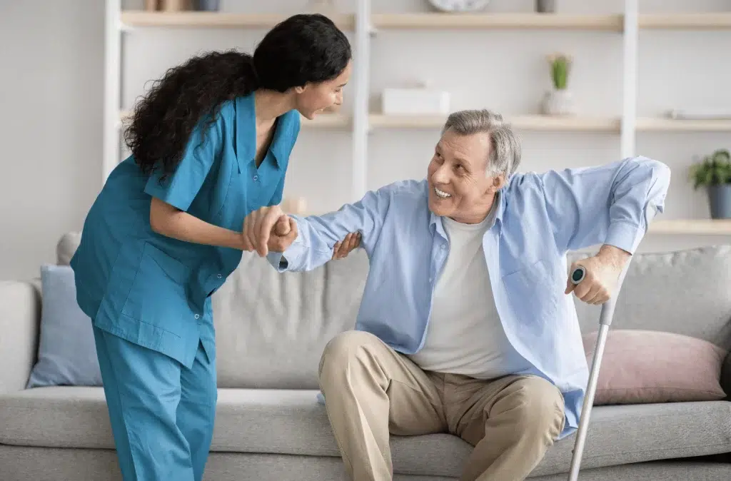 A healthcare worker smiling and providing care to an elderly woman, illustrating the support provided under the UK Health and Care Worker Visa.