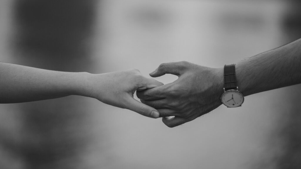 Couple holding hands symbolising love and commitment, representing the evidence required to prove a genuine relationship for a UK Spouse Visa.
